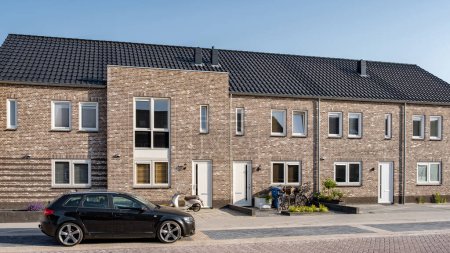 Neugebaute Häuser mit Sonnenkollektoren auf dem Dach vor sonnigem Himmel, Wohnungsmarkt in den Niederlanden