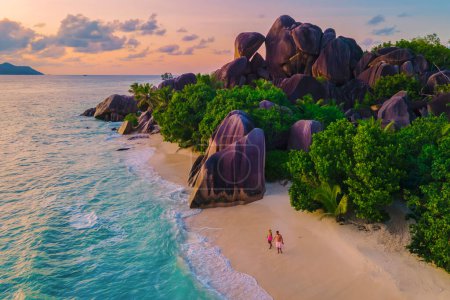 Photo for Anse Source dArgent beach, La Digue Island, Seyshelles, Drone aerial view of La Digue Seychelles bird eye view.of tropical Island, couple men and woman walking at the beach during sunset at a luxury - Royalty Free Image
