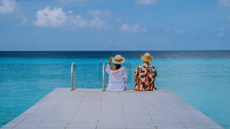 Téléchargez les photos : Un couple visitent Playa Porto Marie plage Curaçao, plage tropicale blanche avec eau turquoise océan, couple hommes et femmes en vacances à Curaçao - en image libre de droit