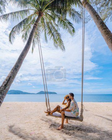 Téléchargez les photos : Couple sur la plage à Phuket détente sur une chaise balançoire de plage, plage tropicale à Phuket Thaïlande. Plage de Nakalay - en image libre de droit