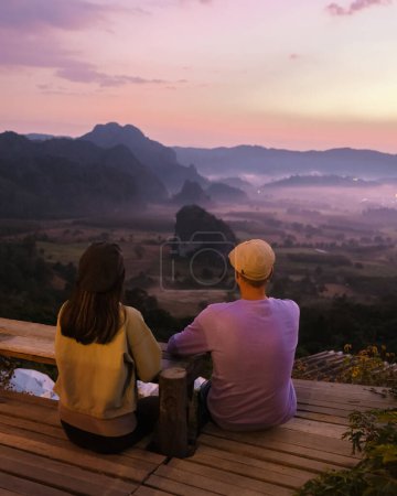 Photo for A couple of men and women watching the Sunrise with fog and mist at Phu Langka mountains in Northern Thailand, Mountain View of Phu Langka National Park at Phayao Province - Royalty Free Image