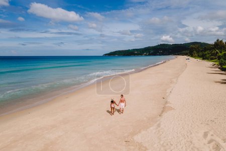 Téléchargez les photos : Drone view at a couple walking on the beach of Karon Phuket Thailand during vacation - en image libre de droit