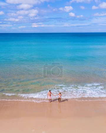 Foto de Drone view at a couple walking on the beach of Karon Phuket Thailand during vacation - Imagen libre de derechos