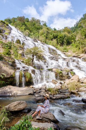 Photo for Thai Asian women visit Mae Ya Waterfall Doi Inthanon national park Thailand Chiang Mai. - Royalty Free Image