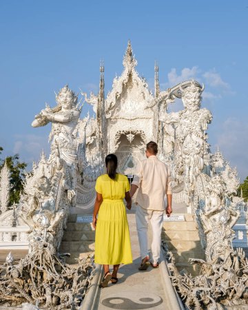 Foto de A couple visits the White Temple Chiang Rai Thailand, Wat Rong Khun, aka The White Temple, in Chiang Rai, Thailand. Asian women and Caucasian men visit a temple - Imagen libre de derechos