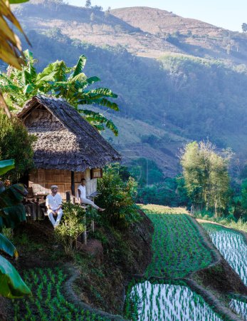 Téléchargez les photos : A Couple visits a rice farm with rice fields in Northern Thailand, and rice paddies in the mountains Chiang Mai, couple man and woman at a farm stay - en image libre de droit
