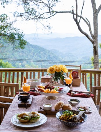 Téléchargez les photos : Vue de dessus d'un petit déjeuner de luxe dans les montagnes de Chiang Mai Thaïlande, petit déjeuner de luxe avec soupe de nouilles au curry Chiang Mai ou Khao soi gai et fruits et café sur la table. - en image libre de droit