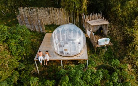 Téléchargez les photos : A couple of men and women staying at a luxury glamping tent in the mountains - en image libre de droit