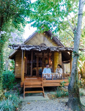 Foto de A couple of men and women at a bamboo hut homestay in Northern Thailand - Imagen libre de derechos