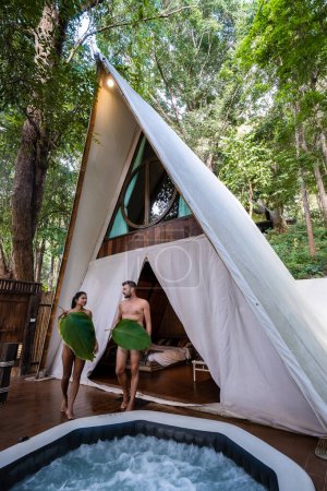 Foto de A couple of men and women staying at a luxury glamping tent in the mountains - Imagen libre de derechos