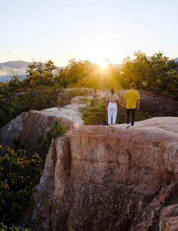 Téléchargez les photos : Couple watching the sunset at Pai Canyon during sunset in Pai Mae Hong Son Northern Thailand, Tourists enjoy the beautiful sunset at Pai Canyon, or Kong Lan how. - en image libre de droit