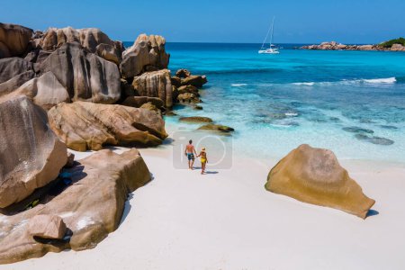 Photo for Anse Cocos beach, La Digue Island, Seychelles, Drone aerial view of La Digue Seychelles bird eye view.of tropical Island, couple men and woman walking at the beach during sunset at a luxury vacation - Royalty Free Image