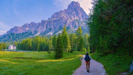 Photo for Woman hiking in the Italian Dolomites, a Girl hiking to Lago Di Sorapis in the Italian Dolomites Italy, woman mid age Asian walking in the mountains with a backpack - Royalty Free Image
