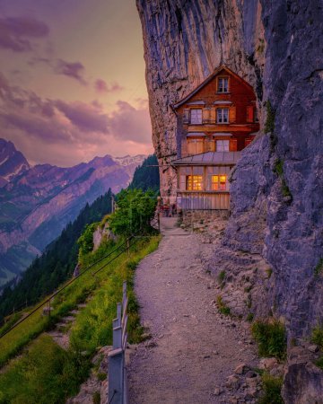 Foto de Alpes suizos y un restaurante de montaña bajo el acantilado de Aescher visto desde la montaña Ebenalp en la región de Appenzell en Suiza Acantilado de Aescher Suiza - Imagen libre de derechos