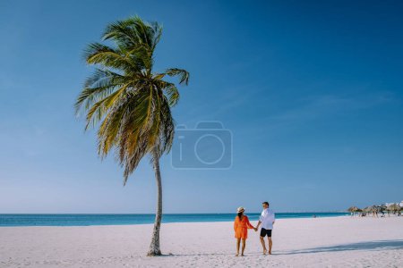 Photo for Eagle Beach Aruba, Palm Trees on the shoreline of Eagle Beach in Aruba, couple man, and woman on the beach of Aruba - Royalty Free Image
