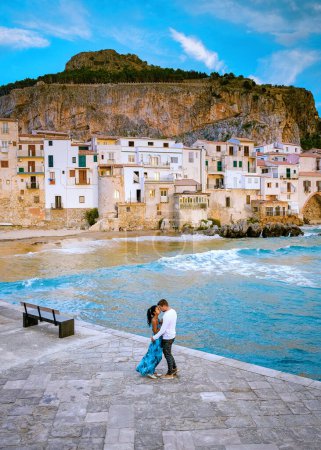 Téléchargez les photos : Couple on vacation in Sicily visiting the old town of Cefalu, sunset at the beach of Cefalu Sicily, the old town of Cefalu Sicilia panoramic view at the colorful village.Italy - en image libre de droit
