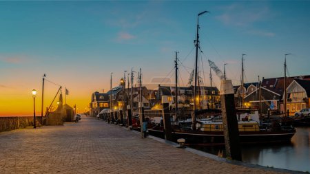 Téléchargez les photos : Urk Flevoland Netherlands sunset at the lighthouse and harbor of Urk Holland. Traditional Fishing village Urk. Beautiful sunset during the evening - en image libre de droit