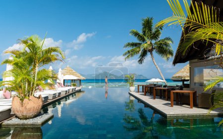 Téléchargez les photos : Young men at a swimming pool at a luxury hotel, a Luxury swimming pool in a tropical resort - en image libre de droit