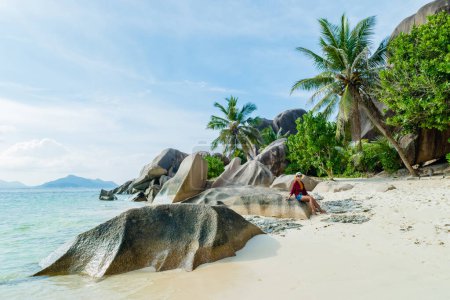 Photo for Young woman at Anse Source dArgent beach La Digue Seychelles Islands, white tropical beach with granite boulders. - Royalty Free Image