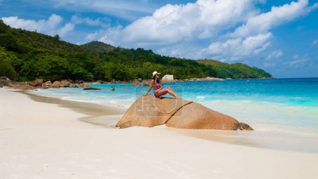 Téléchargez les photos : Jeune femme asiatique avec un chapeau sur une plage tropicale blanche Anse Lazio plage Praslin Tropical Seychelles Islands. - en image libre de droit