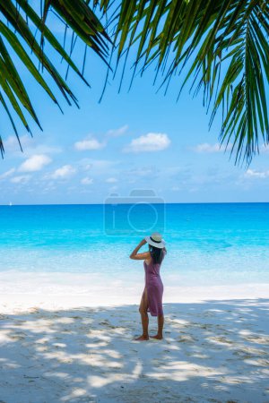 Foto de Young Asian woman at a white tropical beach Anse Lazio beach Praslin Tropical Seychelles Islands. - Imagen libre de derechos