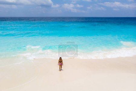 Téléchargez les photos : Woman walking at the beach, Drone view from above at a tropical beach in the Seychelles Cocos Island - en image libre de droit