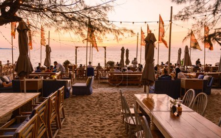Photo for Pattaya Thailand January 2022, people dining on the beach during sunset at the restaurant the Glasshouse in Najomtien, Jomtien - Royalty Free Image