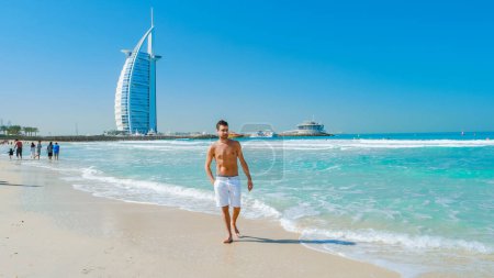 Photo for Young man in a swim short on the beach in Dubai, Jumeirah beach Dubai United Arab Emirates on a sunny day. - Royalty Free Image