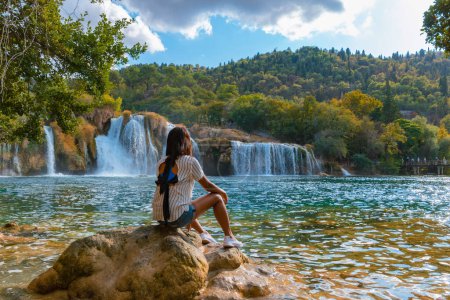 Photo for KRKA waterfalls Croatia during summer, young Asian women watch the waterfalls of krka national park Croatia on a bright summer evening in the park. - Royalty Free Image