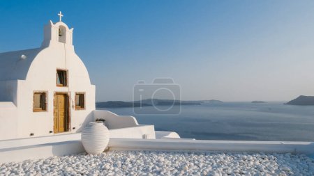 Photo for Oia Santorini Greece on a sunny day during summer with whitewashed homes and churches, Greek Island Aegean Cyclades on a sunny day with blue ocean - Royalty Free Image