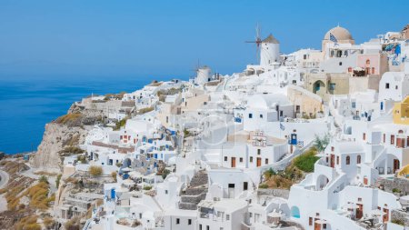 Photo for Oia Santorini Greece on a sunny day during summer with whitewashed homes and churches, Greek Island Aegean Cyclades on a sunny day with blue ocean - Royalty Free Image