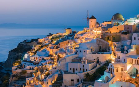 Foto de Sunset at the village of Oia Santorini Greece during summer with whitewashed homes and churches, Greek Island Aegean Cyclades - Imagen libre de derechos