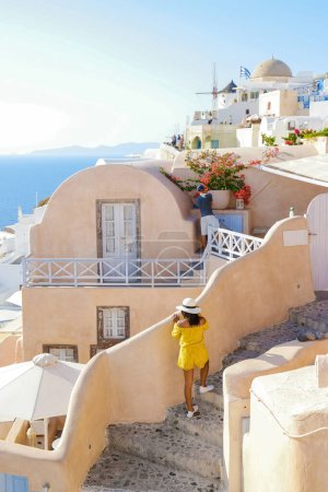 Téléchargez les photos : Asian women visit Oia Santorini Greece on a sunny day during summer with whitewashed homes and churches, Greek Island Aegean Cyclades - en image libre de droit