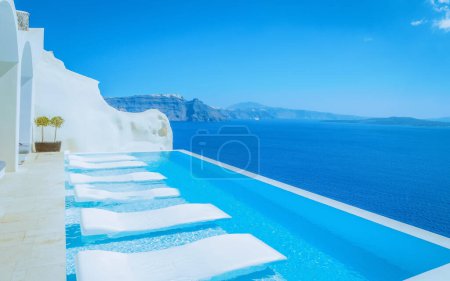 Téléchargez les photos : Vacation at Santorini swimming pool looking out over the Caldera ocean of Santorini, Oia Greece, Greek Island Aegean Cyclades. - en image libre de droit