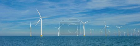 Téléchargez les photos : Drone view at wind mill turbines, Windmill park with clouds and a blue sky, windmill park in the ocean aerial view with wind turbine Flevoland Netherlands Ijsselmeer - en image libre de droit