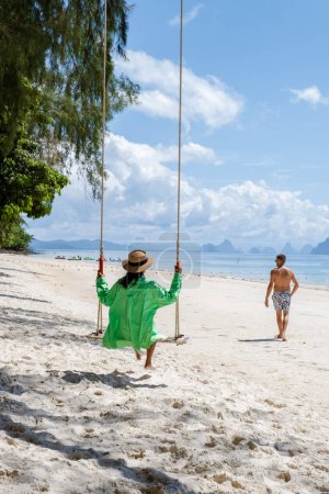 Téléchargez les photos : A couple on a swing on the beach in Phuket Thailand. - en image libre de droit