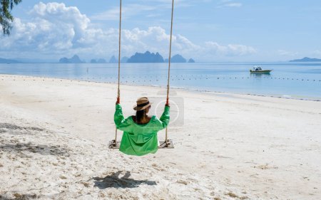 Photo for A woman on a swing on the beach in Phuket Thailand, women on a tropical beach in Thailand. - Royalty Free Image