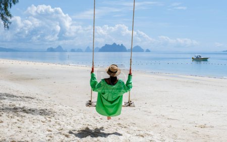 Téléchargez les photos : Une femme sur une balançoire sur la plage à Phuket en Thaïlande, des femmes sur une plage tropicale en Thaïlande. - en image libre de droit