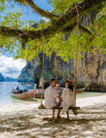 Foto de Men and women at the Tropical lagoon of Koh Loa Lading Krabi Thailand part of the Koh Hong Islands in Thailand. beautiful beach with limestone cliffs and longtail boats - Imagen libre de derechos