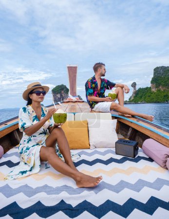 Foto de Luxury Longtail boat in Krabi Thailand, couple man, and woman on a trip to the tropical island 4 Island trip in Krabi Thailand with Chicken Island in the background. - Imagen libre de derechos