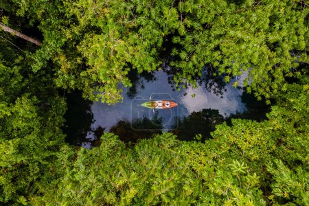 Photo for Couple in a kayak in the jungle of Krabi Thailand, men and women in a kayak at a tropical jungle in Krabi mangrove forest. - Royalty Free Image