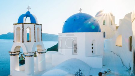 Téléchargez les photos : Oia Santorini Greece on a sunny day during summer with whitewashed homes and churches, Greek Island Aegean Cyclades on a sunny day with blue ocean - en image libre de droit