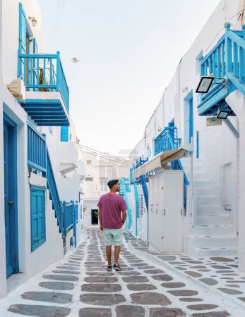 Photo for Young men visit Mykonos Greek village in Greece, with colorful streets of Mikonos village. - Royalty Free Image