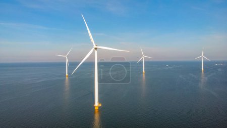 Téléchargez les photos : Windmill park Westermeerdijk Pays-Bas, éolienne avec ciel bleu dans l'océan, énergie verte, concept de réchauffement climatique - en image libre de droit