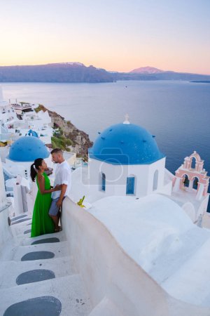Photo for Couple hugging and kissing on a romantic vacation in Santorini Greece, men and women visit the whitewashed Greek village of Oia . - Royalty Free Image
