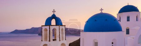 Téléchargez les photos : White churches an blue domes by the ocean of Oia Santorini Greece, a traditional Greek village in Santorini during summer - en image libre de droit