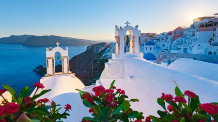 Foto de Puesta de sol en el océano de Oia Santorini Grecia, un pueblo griego tradicional en Santorini con iglesias encaladas y cúpulas azules - Imagen libre de derechos
