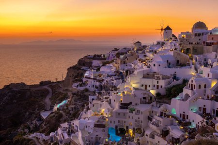 Téléchargez les photos : Sunset with white churches an blue domes by the ocean of Oia Santorini Greece. - en image libre de droit