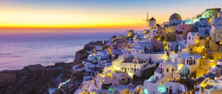 Foto de Puesta de sol en el océano de Oia Santorini Grecia, un pueblo griego tradicional en Santorini con iglesias encaladas y cúpulas azules - Imagen libre de derechos