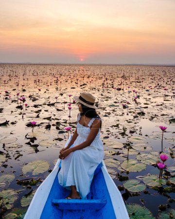 Foto de Thai women in a boat at the Beautiful Red Lotus Sea Kumphawapi is full of pink flowers in Udon Thani in northern Thailand. Flora of Southeast Asia. - Imagen libre de derechos